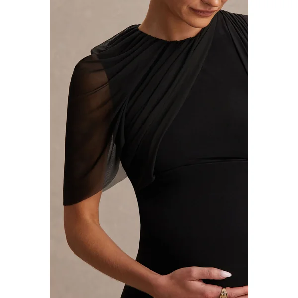 Amelise | Robe de maternité longue noire à col montant avec manche cape en mesh et ceinture fluide