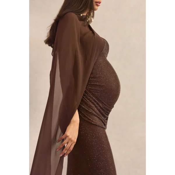 Ottoline | Robe longue de maternité en strass marron foncé à décolleté asymétrique avec manche cape transparente